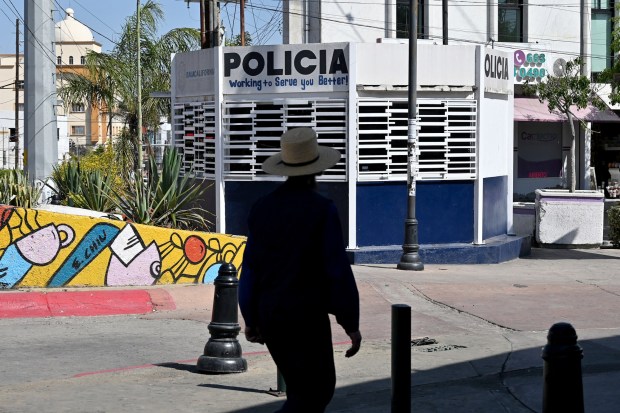A man passes by a Tijuana municipal police station at Revolution Avenue in downtown Tijuana, Mexico on Tuesday, April 07, 2026. Some visitors who come as tourists from the US with California license plates have been given traffic tickets by police trying to extort them for money, in response Tijuana officials have created a phone app for claims of extortion by corrupt cops. (Carlos Moreno / The San Diego Union-Tribune)