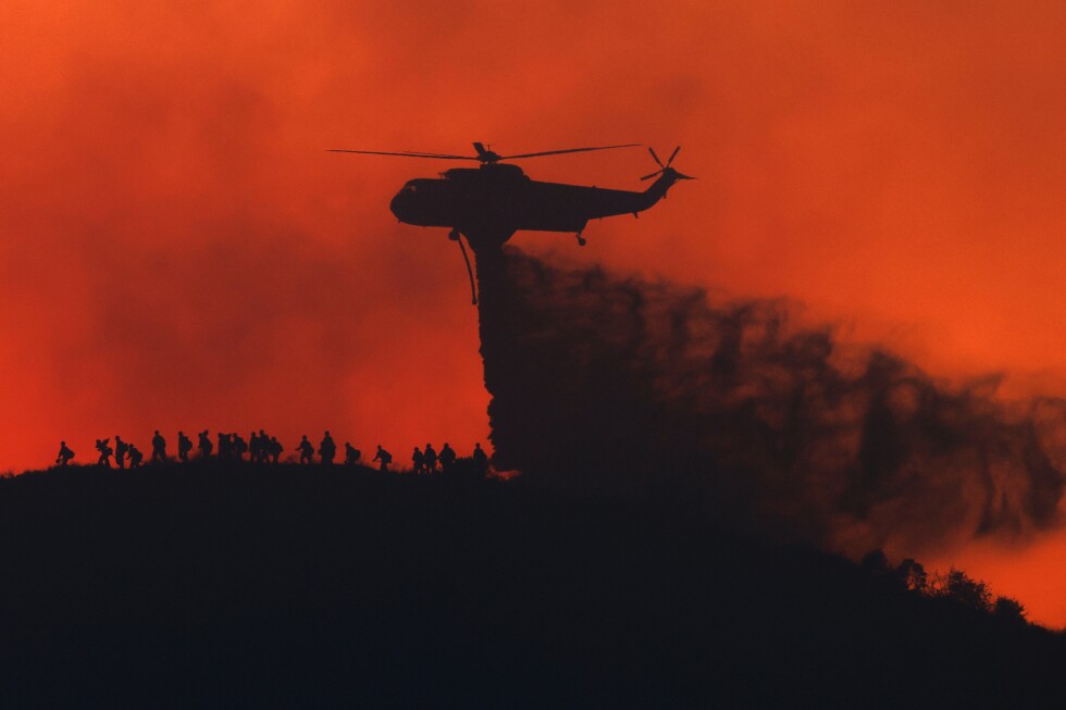 Raging wildfires churn through dry brush in Southern California