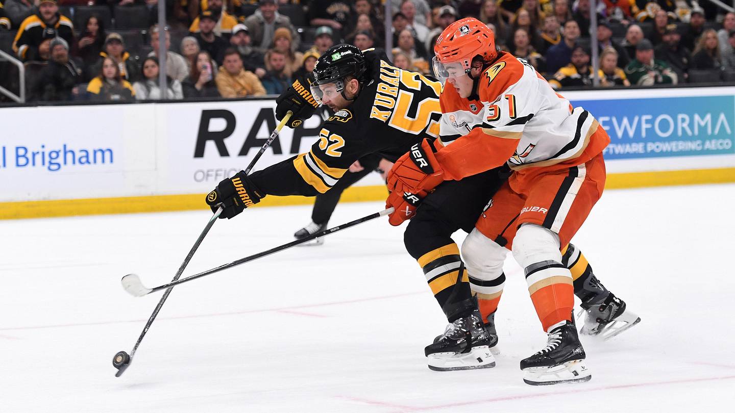 Oct 23, 2025; Boston, Massachusetts, USA; Boston Bruins center Sean Kuraly (52) shoots the puck while Anaheim Ducks defenseman Olen Zellweger (51) defends during the first period at TD Garden. Mandatory Credit: Bob DeChiara-Imagn Images