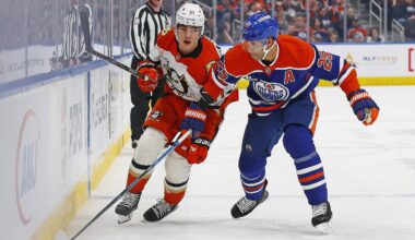 Mar 28, 2026; Edmonton, Alberta, CAN; Anaheim Ducks defensemen Olen Zellweger (51) and Edmonton Oilers defensemen Darnell Nurse (25) chase a loose puck during the second period at Rogers Place. Mandatory Credit: Perry Nelson-Imagn Images