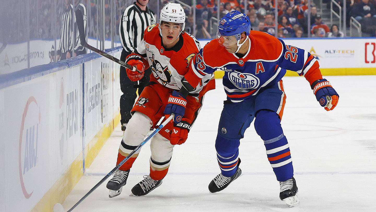 Mar 28, 2026; Edmonton, Alberta, CAN; Anaheim Ducks defensemen Olen Zellweger (51) and Edmonton Oilers defensemen Darnell Nurse (25) chase a loose puck during the second period at Rogers Place. Mandatory Credit: Perry Nelson-Imagn Images