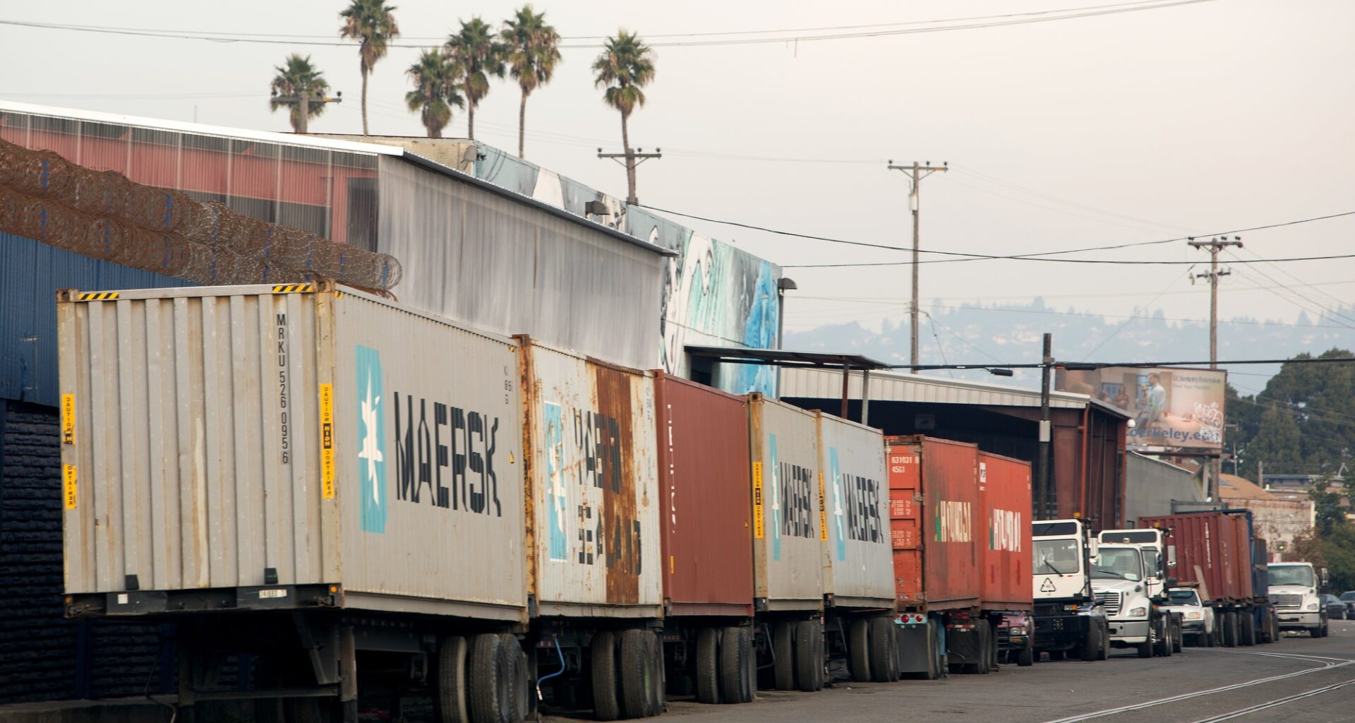 Shipping containers on trailers lined up on a West Oakland street.