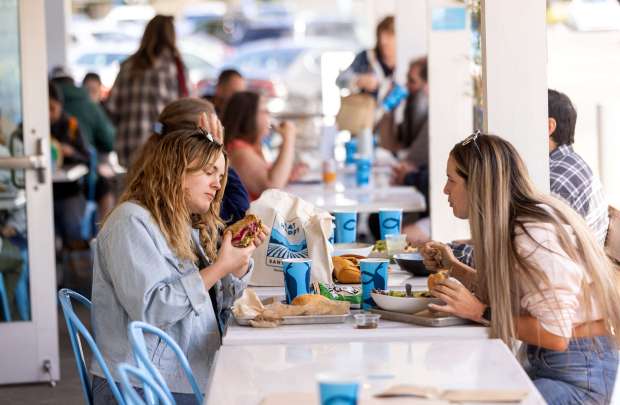 Rachel Chisham, left, inspects her sandwich before trying the new Mendocino Farms restaurant menu Tuesday, May 13, 2025, with friend Haley Novarina in Santa Rosa's Montgomery Village. (John Burgess / The Press Democrat)