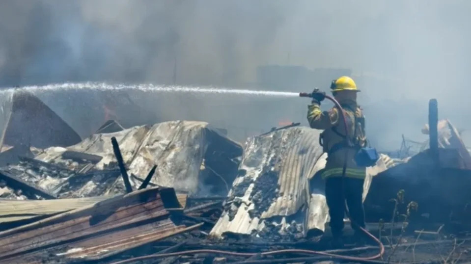 The fire was contained to two acres, but four outbuildings, described as three small sheds and one larger barn-style shed, burned down.