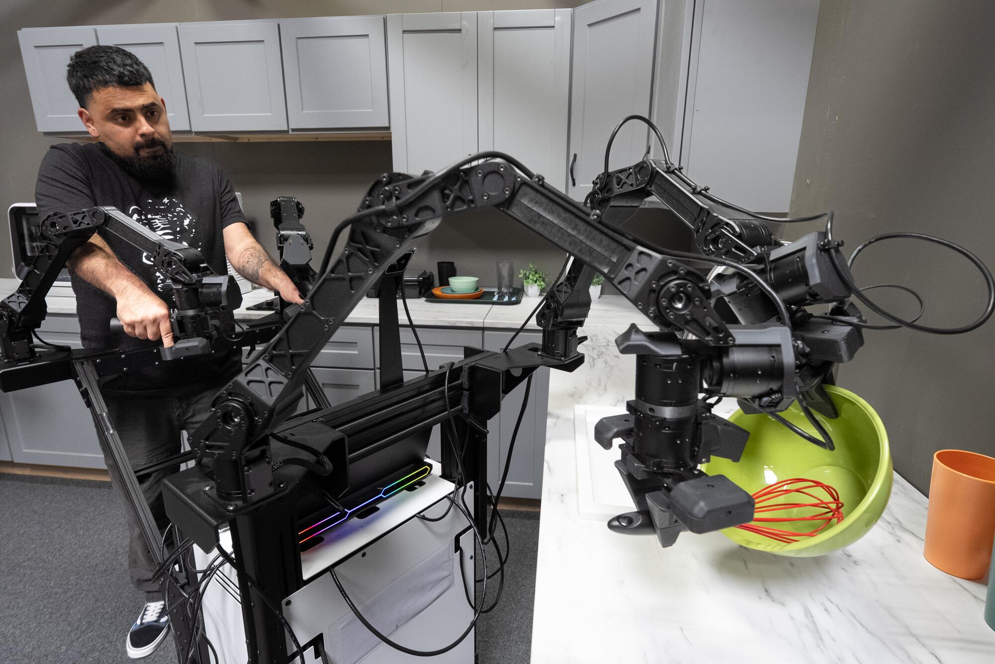 Fernando Flores demonstrates the articulation of a robot performing a whisking motion.