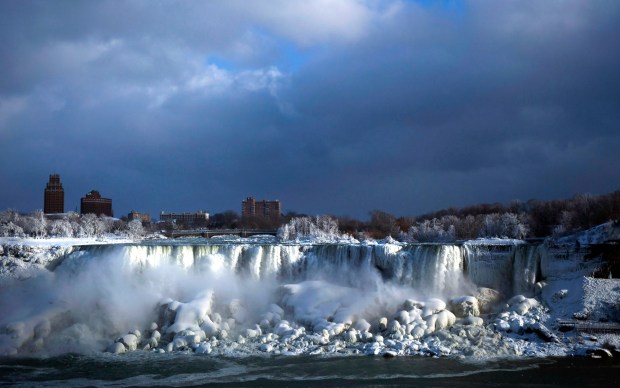 Water flows over the American Falls as ice forms in this view from the Canadian side in Niagara Falls, Ont., Tuesday, Jan. 2, 2018. (Aaron Lynett/The Canadian Press via AP)