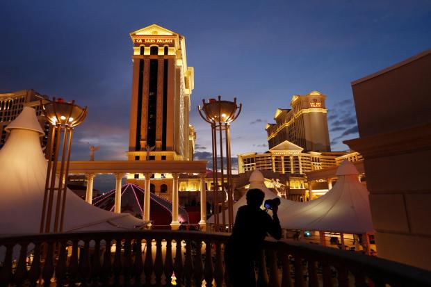 A man takes pictures of Caesars Palace hotel and casino in Las Vegas.