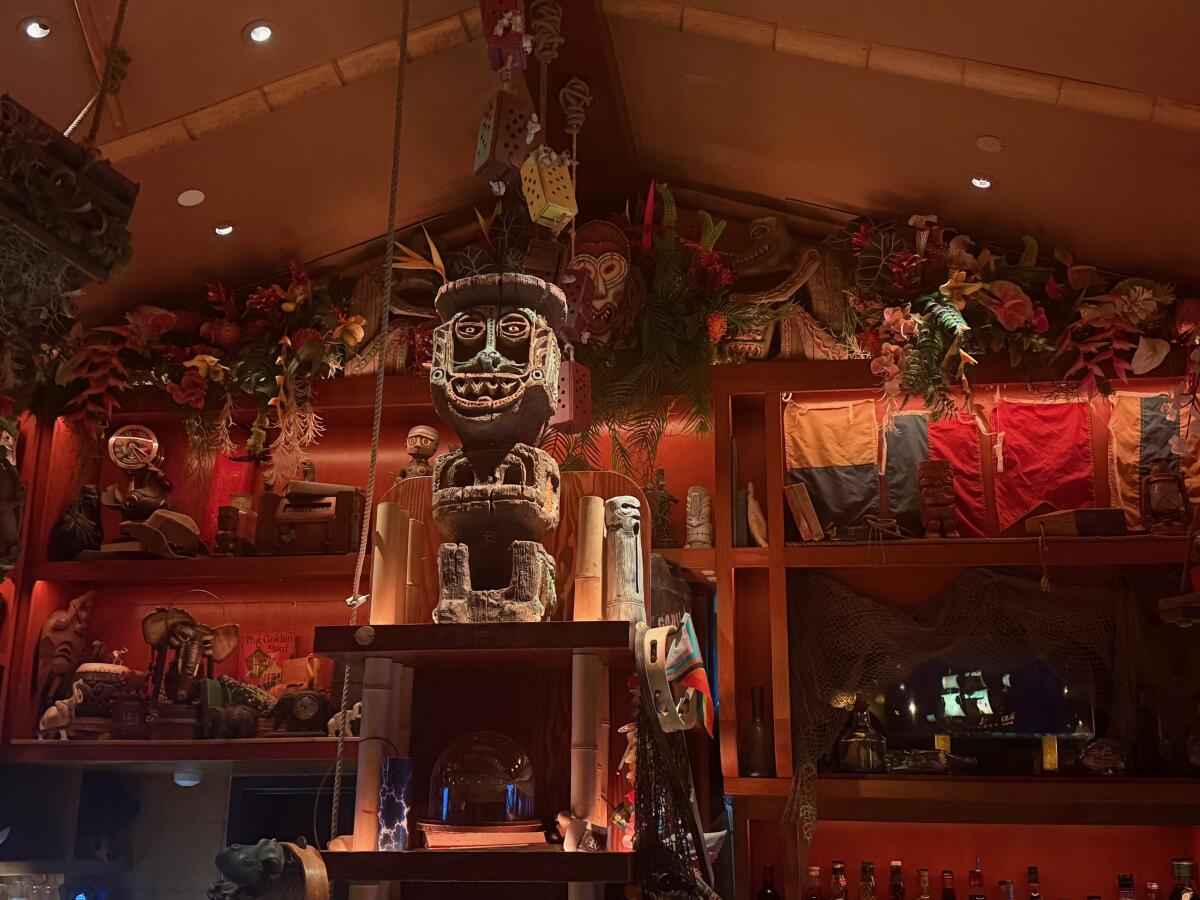 A bar with a tiki god overlooking it. 