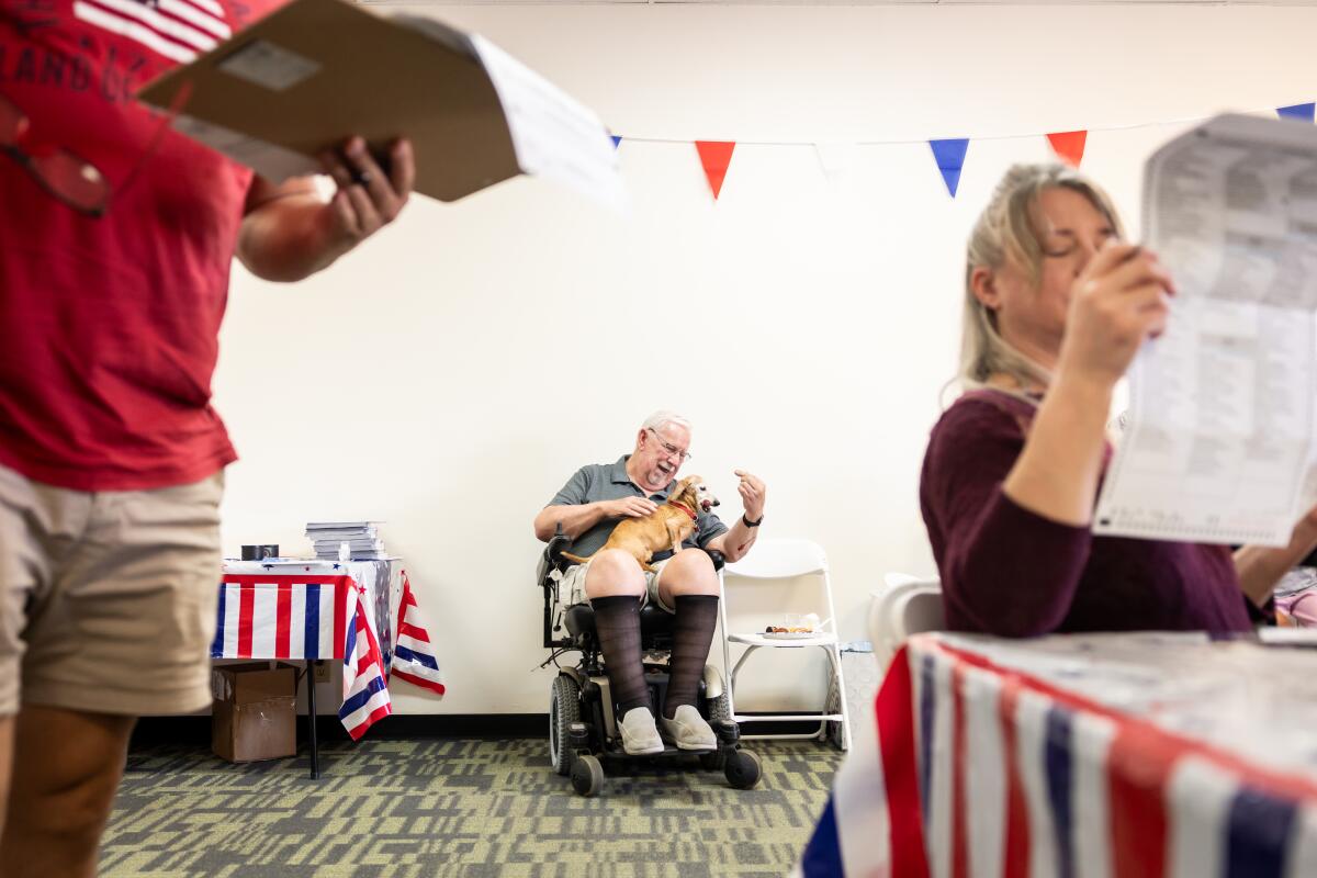 Dan Egelhoff plays with his dog in a room with patriotic decorations  