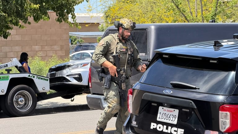 A law enforcement officer responds near a bank where a...