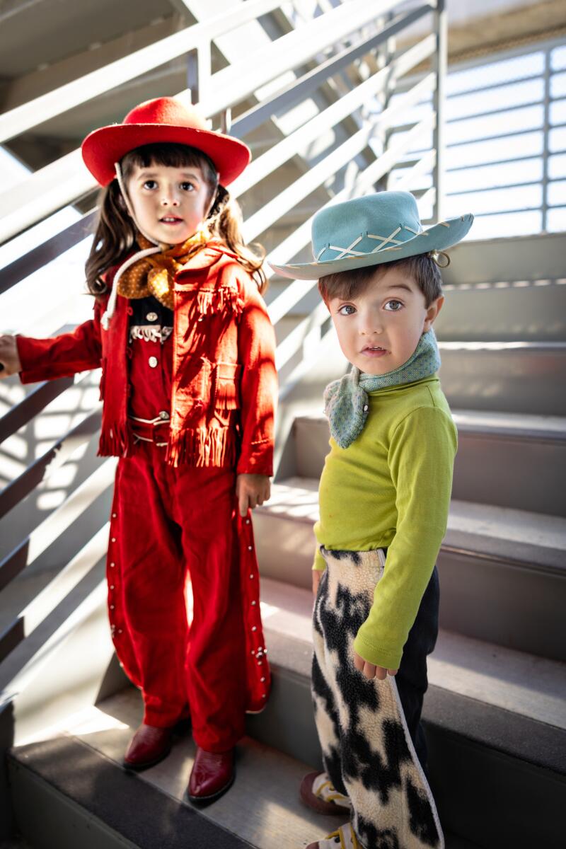 Siblings Amora and Milo Castilo wear vintage cowboy hats, jackets and chaps.