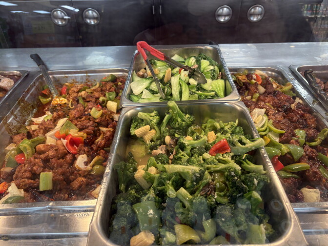 Several metal containers have Chinese style stir-fried food.