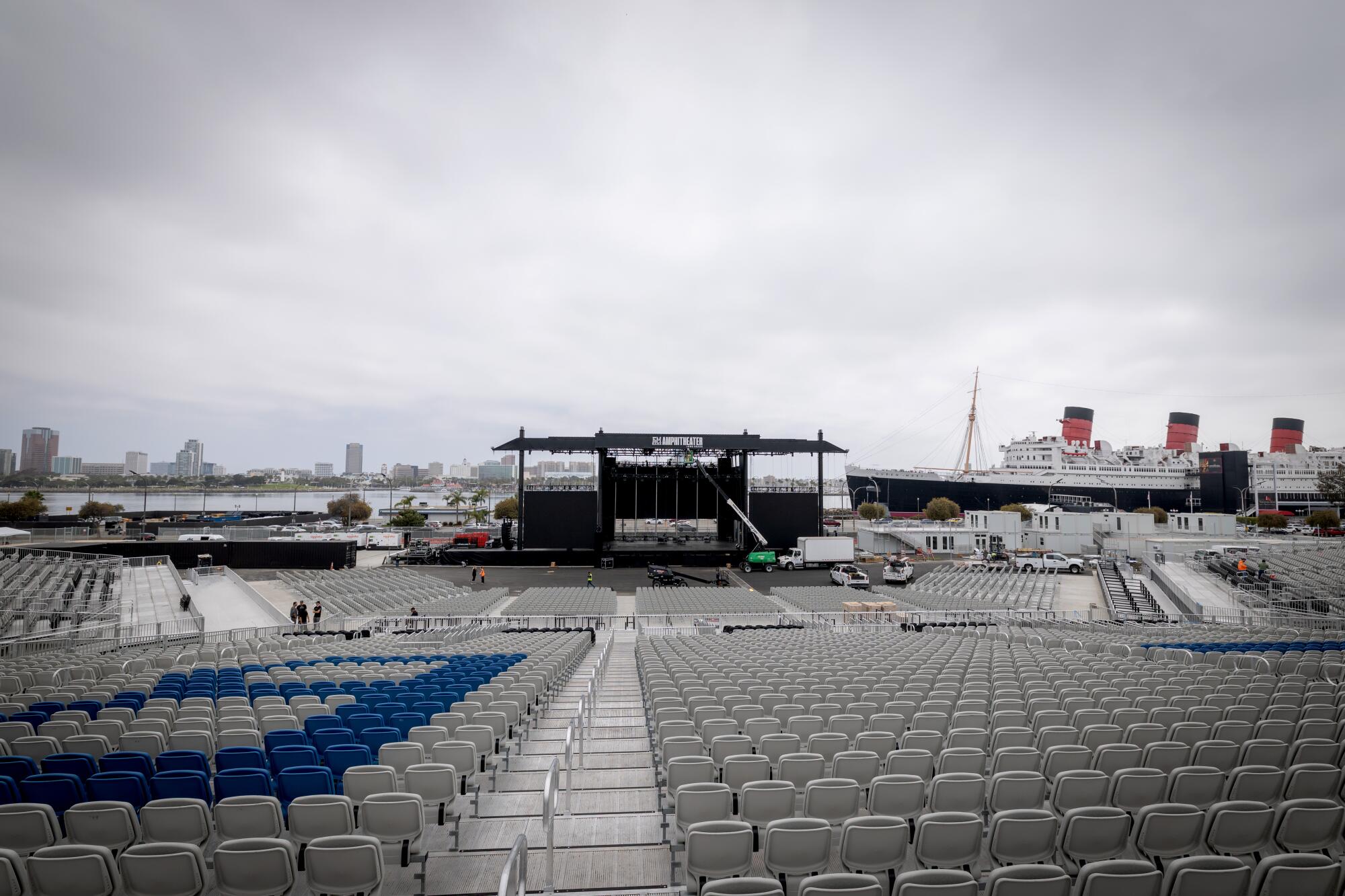 A view of seats leading up to a stage with a construction vehicle parked in front. 
