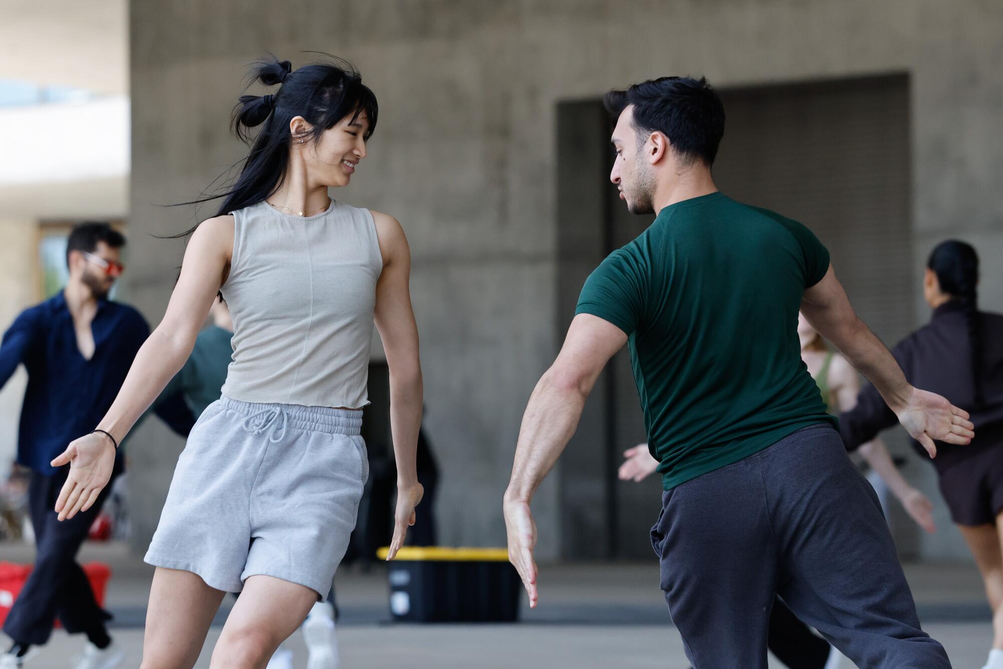 Two dancers perform outdoors.