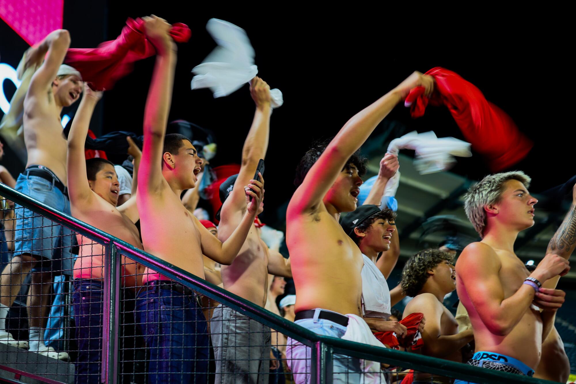 Fans wave their shirts and shout “sell the team” during the eighth inning of an Angels game against the Athletics.