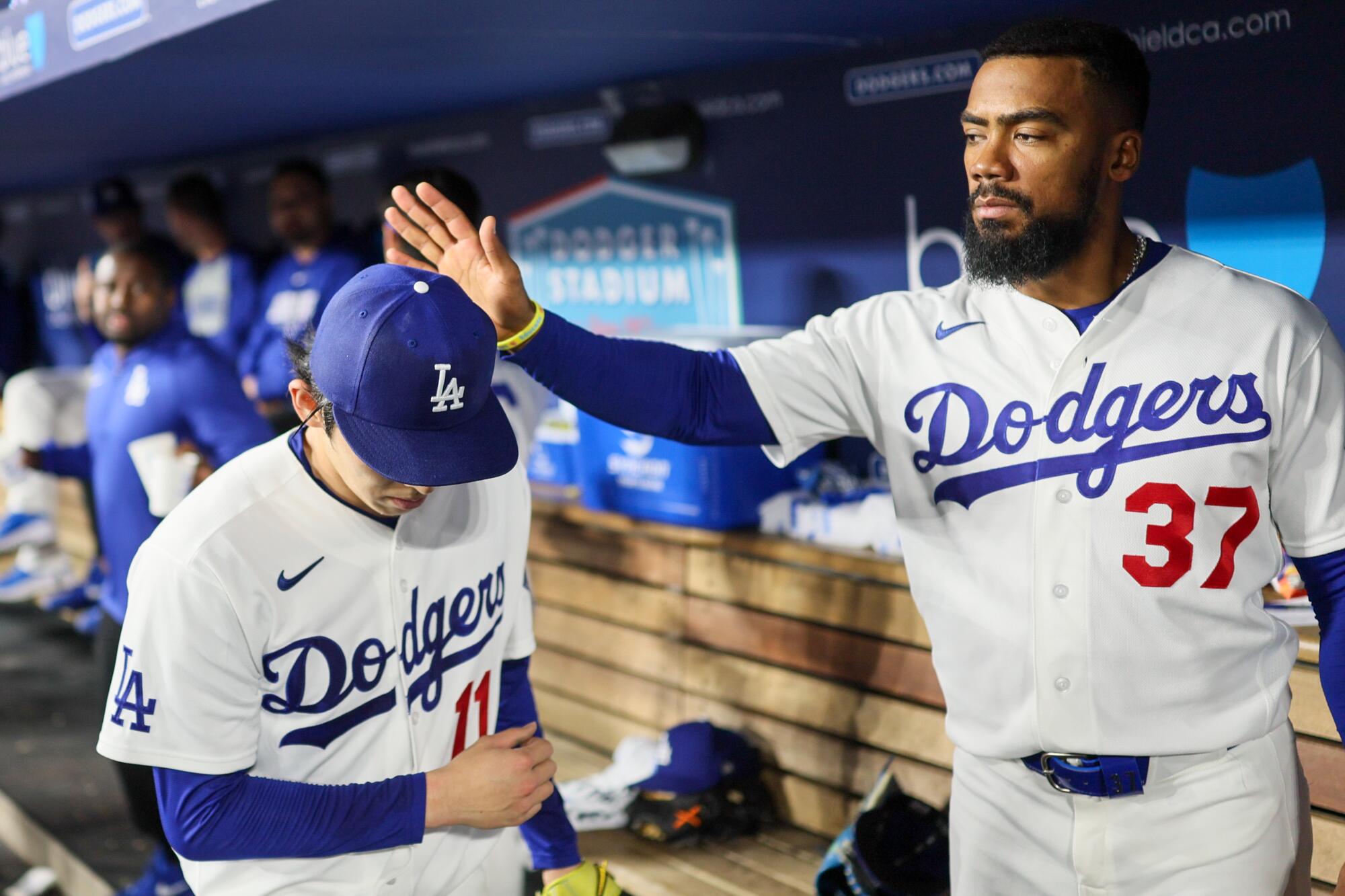 Dodgers left fielder Teoscar Hernández pats pitcher Roki Sasaki on the head in between innings at Dodger Stadium.