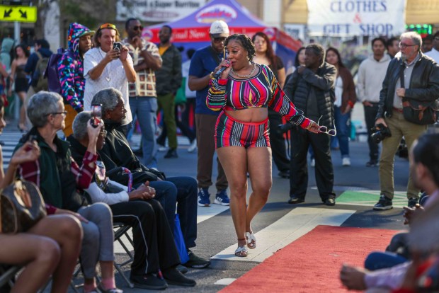 Festivalgoers watch a performer sing before a runway fashion show during the Oakland First Fridays event along Telegraph Avenue in Oakland, Calif., Friday, April 3, 2026. (Ray Chavez/Bay Area News Group)
