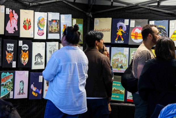 OAKLAND, Calif. Festivalgoers look at art in a vendor's booth during the Oakland First Fridays event along Telegraph Avenue in Oakland, Calif., Friday, April 3, 2026. (Ray Chavez/Bay Area News Group)