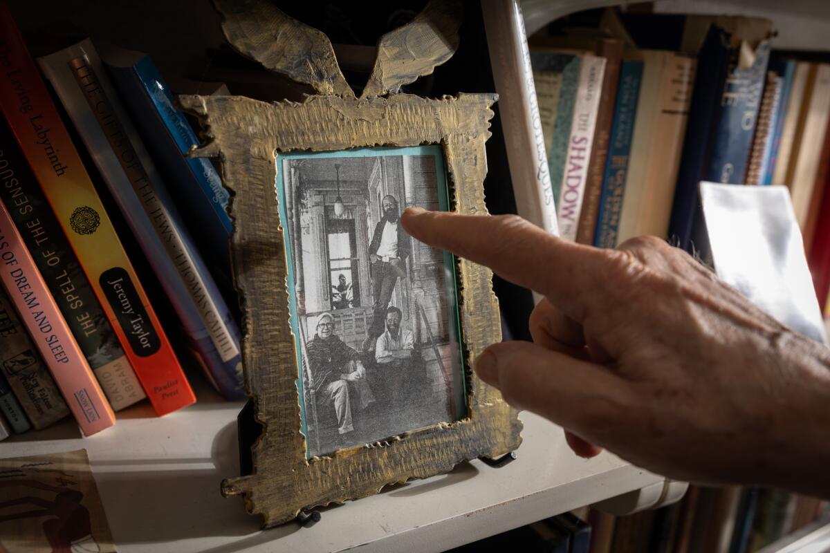 Don Kilhefner displays a black-and-white photo of himself and other LGBTQ+ rights activists in his home in Los Angeles.