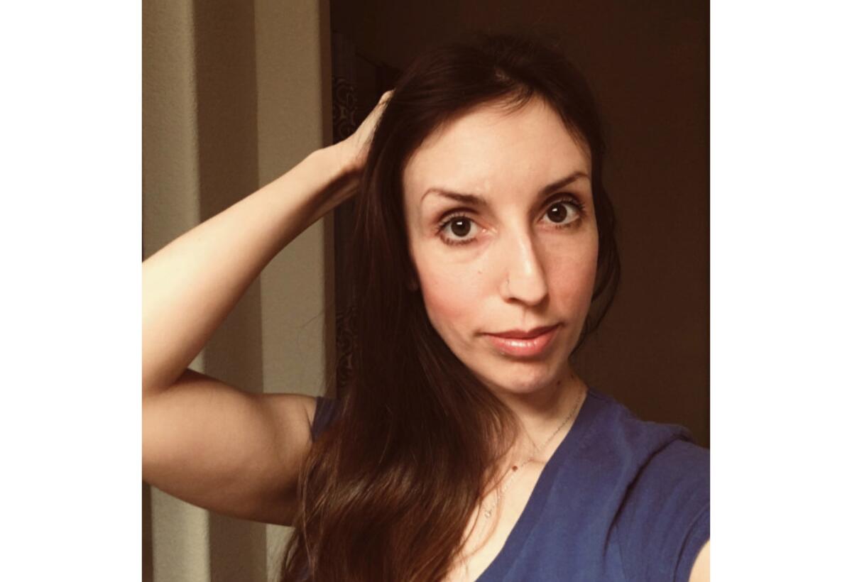 An image of a woman with long dark hair, in a blue shirt