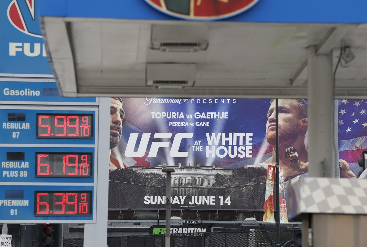 Gas prices for more than $6 a gallon are displayed at an L.A. station near a billboard for the UFC fight at the White House.