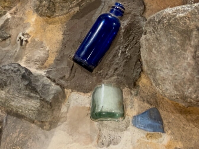 Pieces of glass bottles embedded in an art piece.