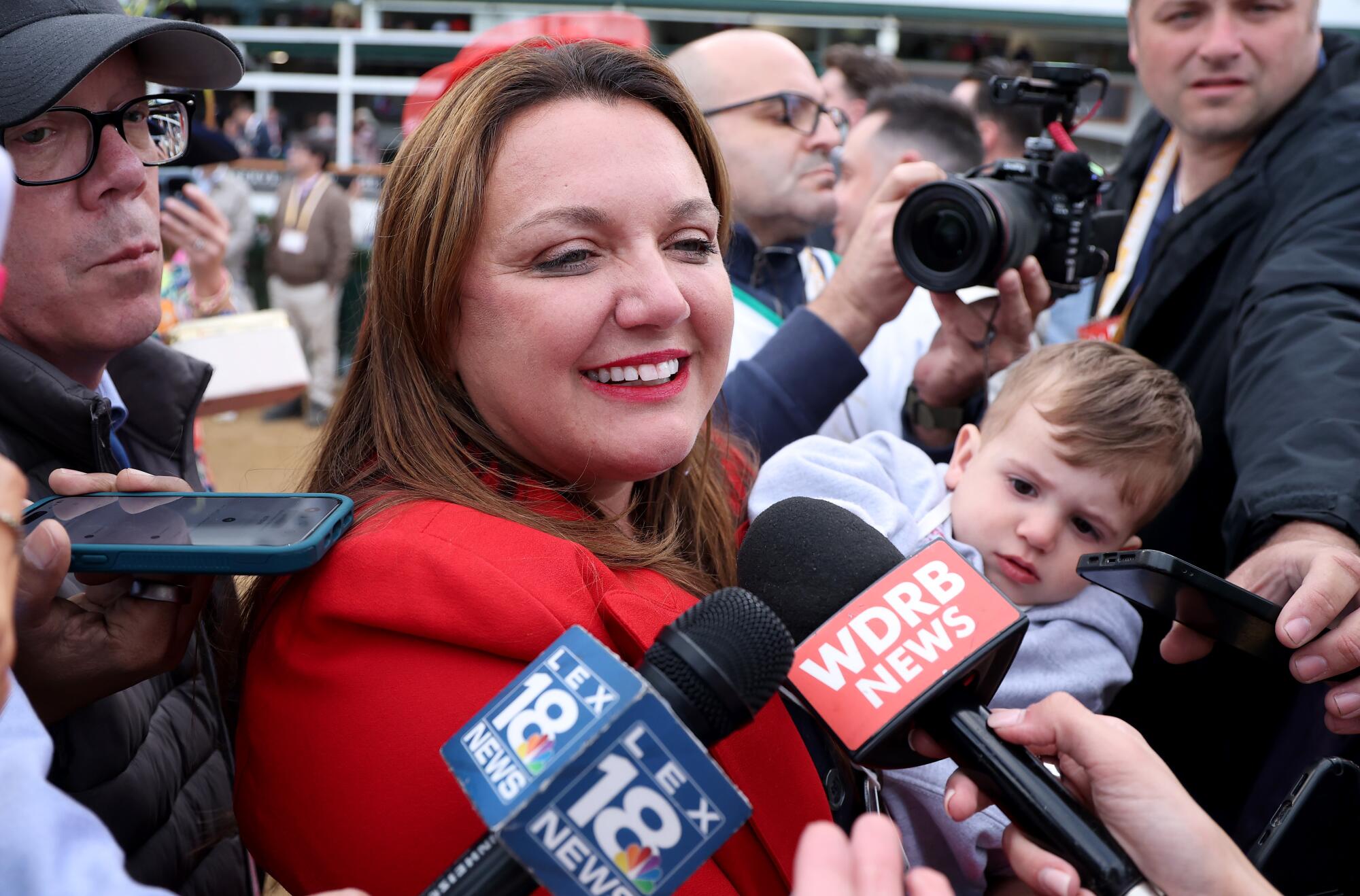 Golden Tempo's trainer Cherie DeVaux holds her nephew while speaking to reporters after winning the Kentucky Derby on May 2.