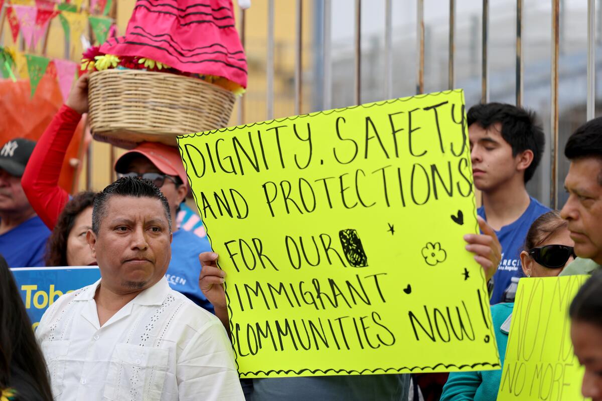Lazaro, left, who did not give his last name, of Los Angeles, stands by as an interpreter translates his speech