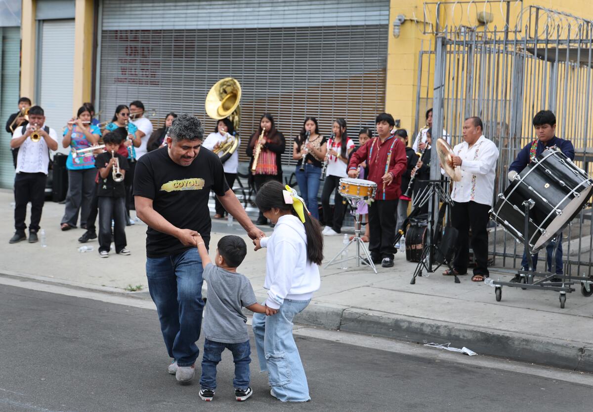 Indigenous Zapotec community members dance as a band performs