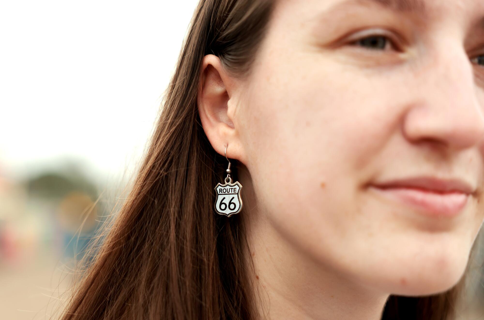 A woman wears an earing with the sign of Route 66