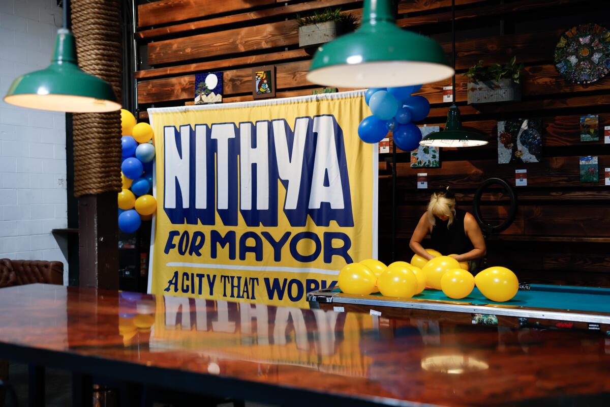Campaign worker Khai Dombroe prepares balloons before Nithya Raman's election night party.