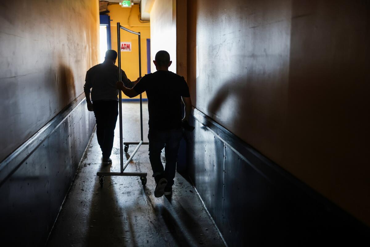Joel Galvez, right, heads to his warehouse with an assistant to collect dresses for delivery.