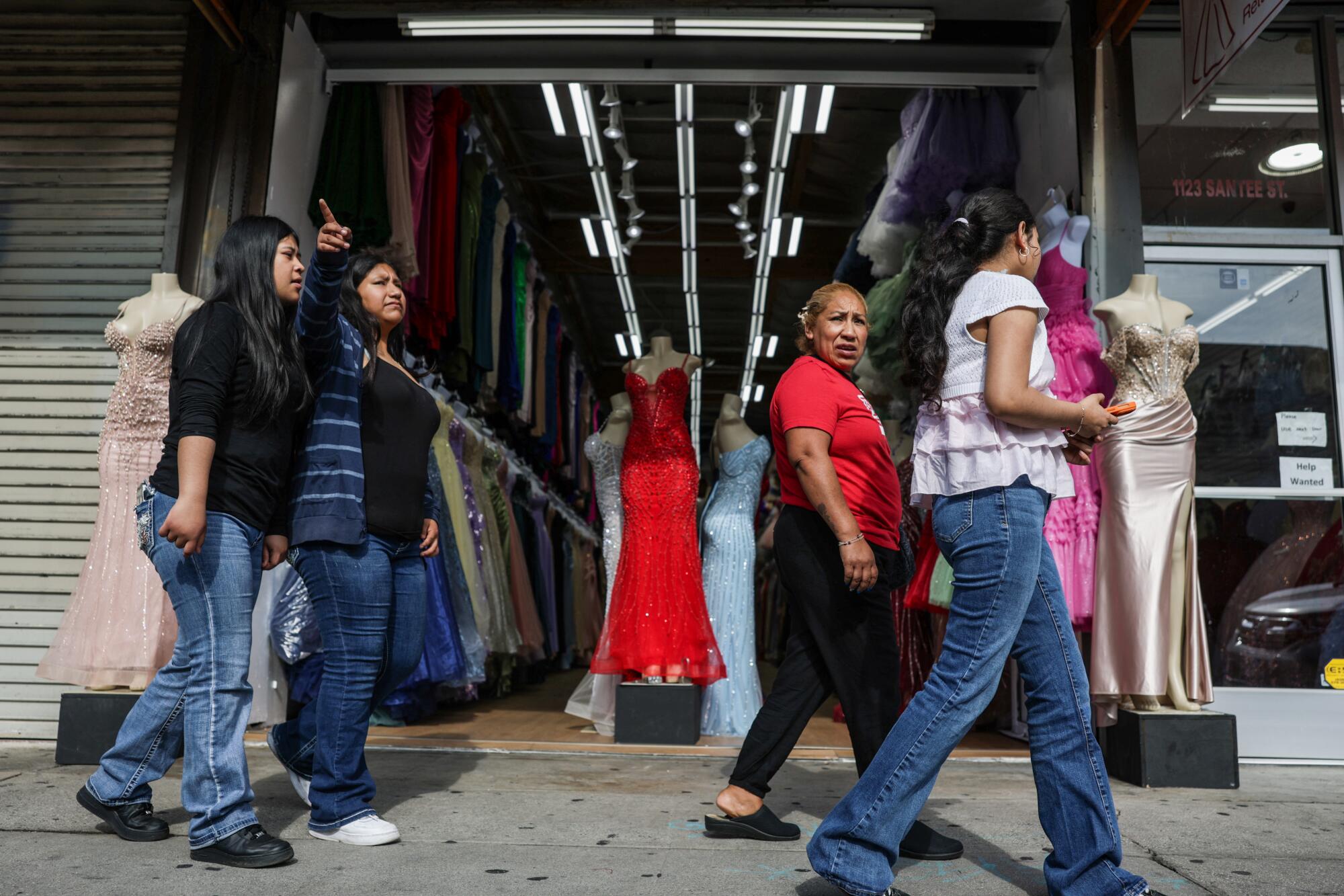 Shoppers stroll past a dress shop