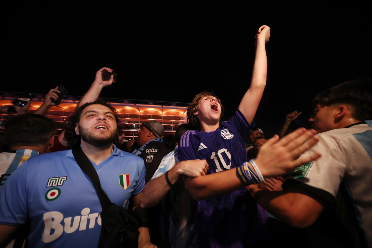 Soccer fans cheer while watching games at a fan festival in Qatar during the 2022 World Cup.