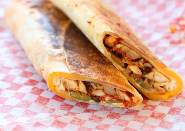 A Shawarma wrap is photographed at Shawarmaji in Oakland, featuring spice-marinated chicken, toum, cucumber pickles, cheddar and shatta sauce wrapped in a flour tortilla. (Aric Crabb/Bay Area News Group)