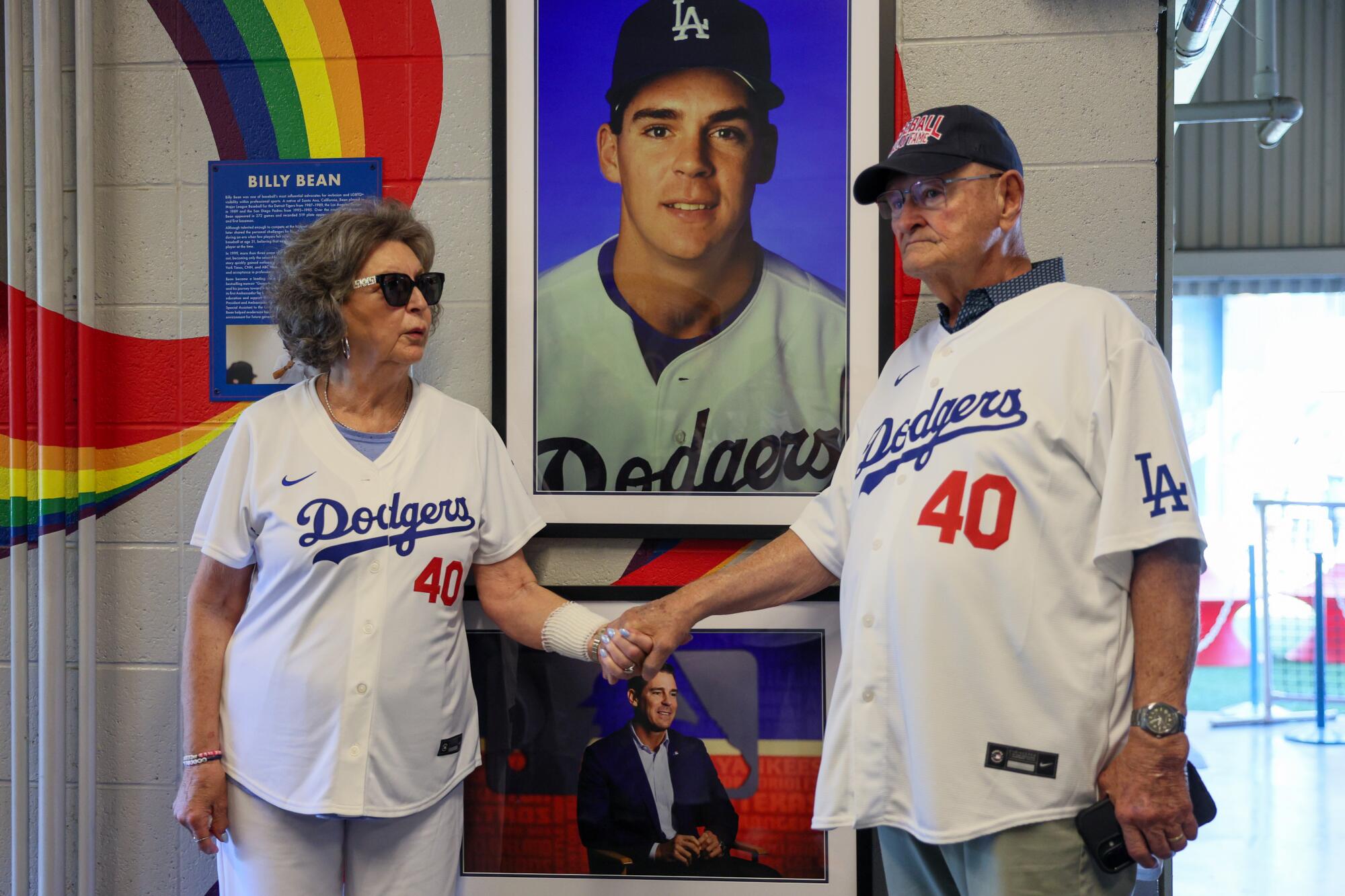 Linda and Ed Kovac, parents of Billy Bean, hold hands in front of a tribute dedicated to their son at Dodger Stadium.