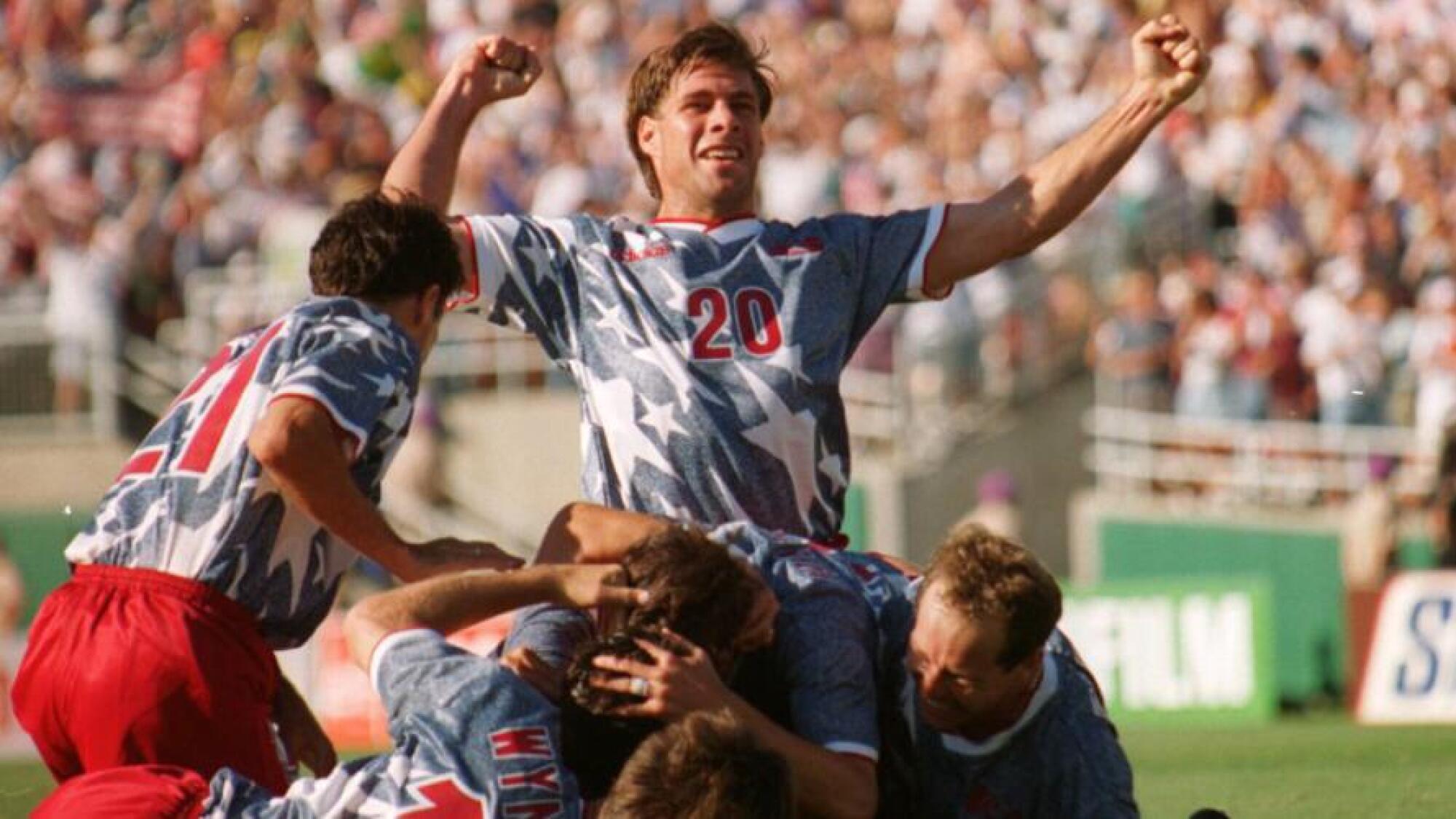 U.S. defender Paul Caligiuri, top, celebrates following a goal by teammate Earnie Stewart in a 2-1 win over Colombia.
