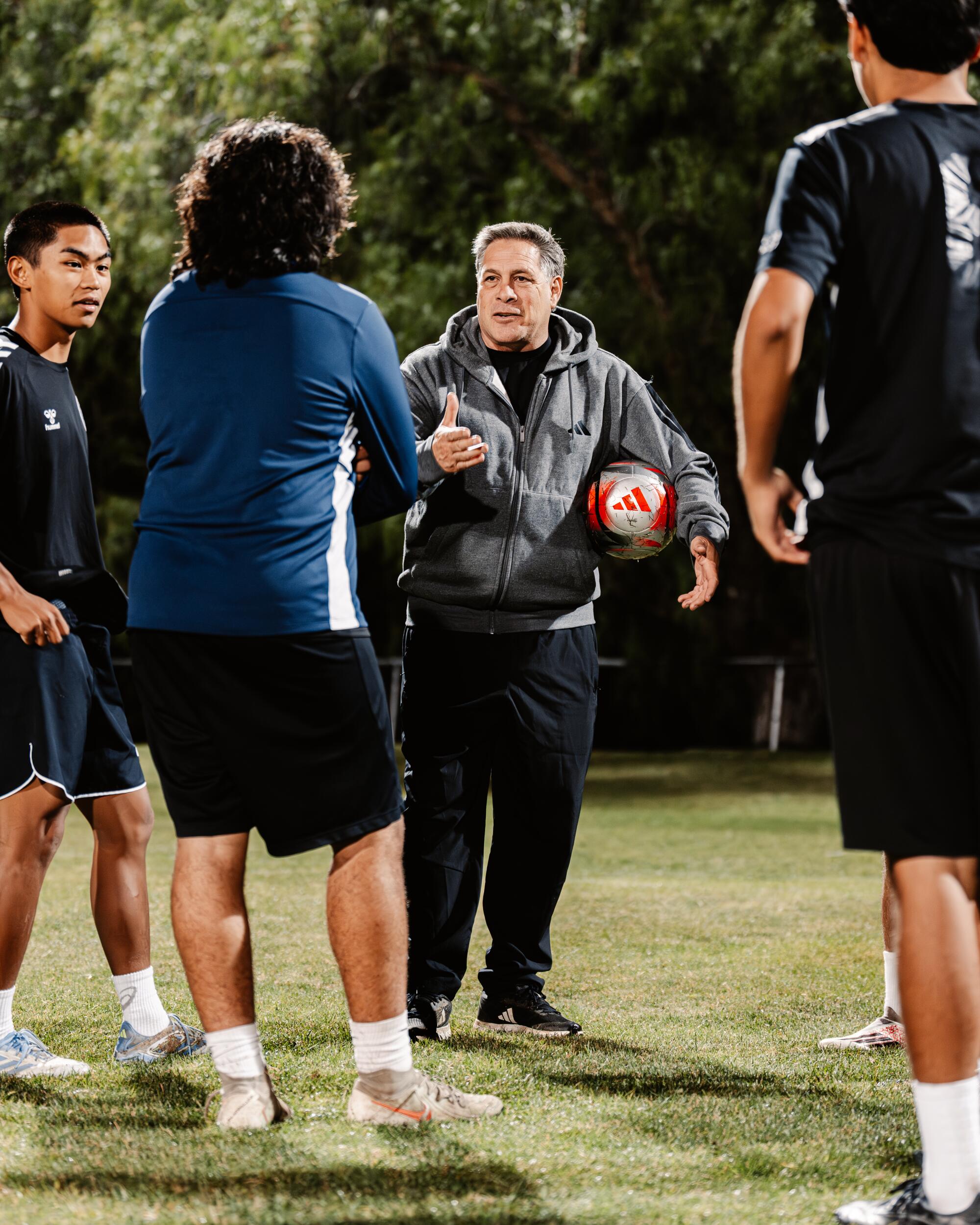 Former U.S. soccer star Paul Caligiuri, center, coaches youth soccer players in Mission Viejo.