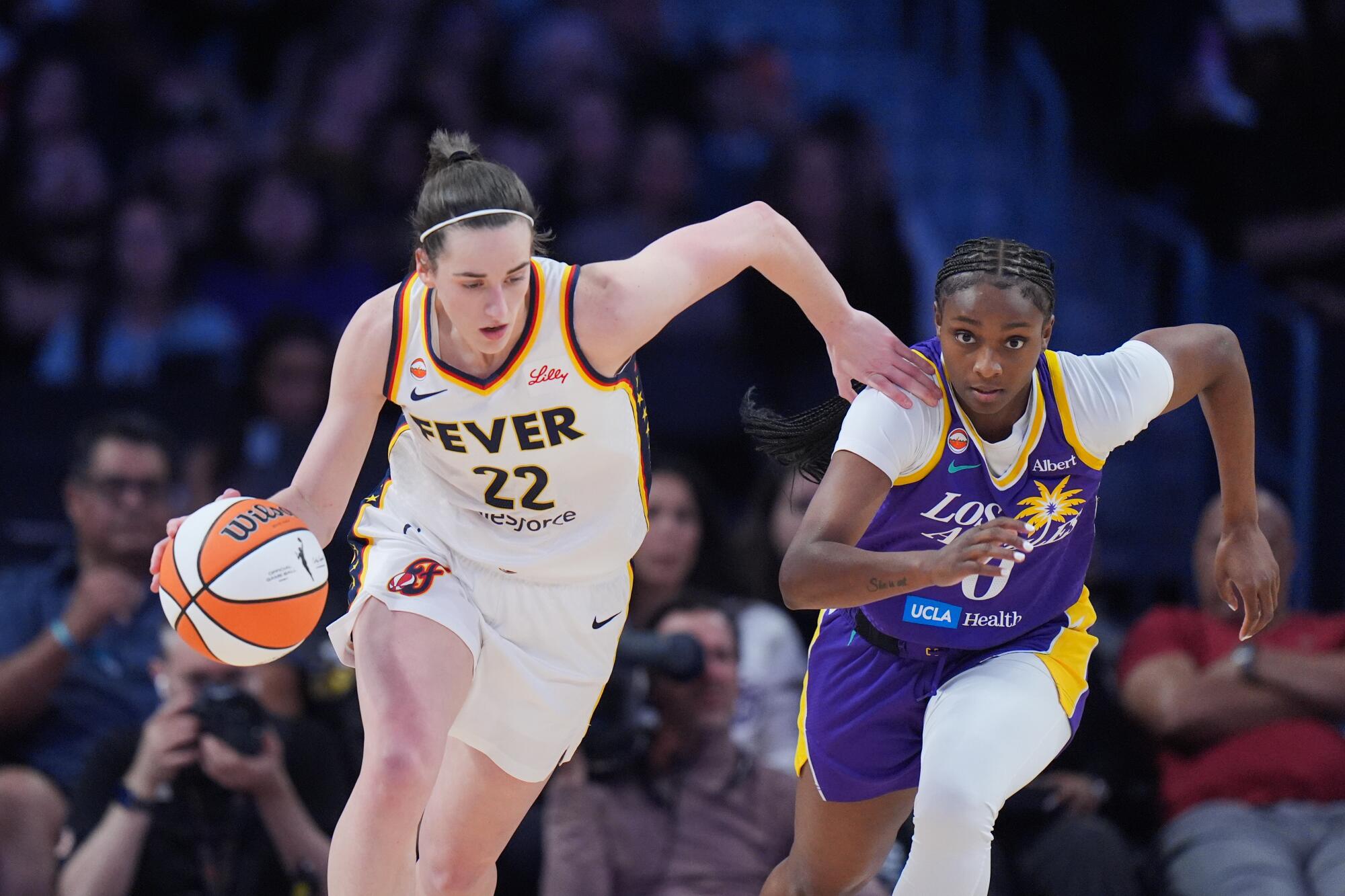 Sparks guard Ta'Niya Latson chases Fever guard Caitlin Clark as she brings the ball upcourt at Crytpo.com Arena on Wednesday.