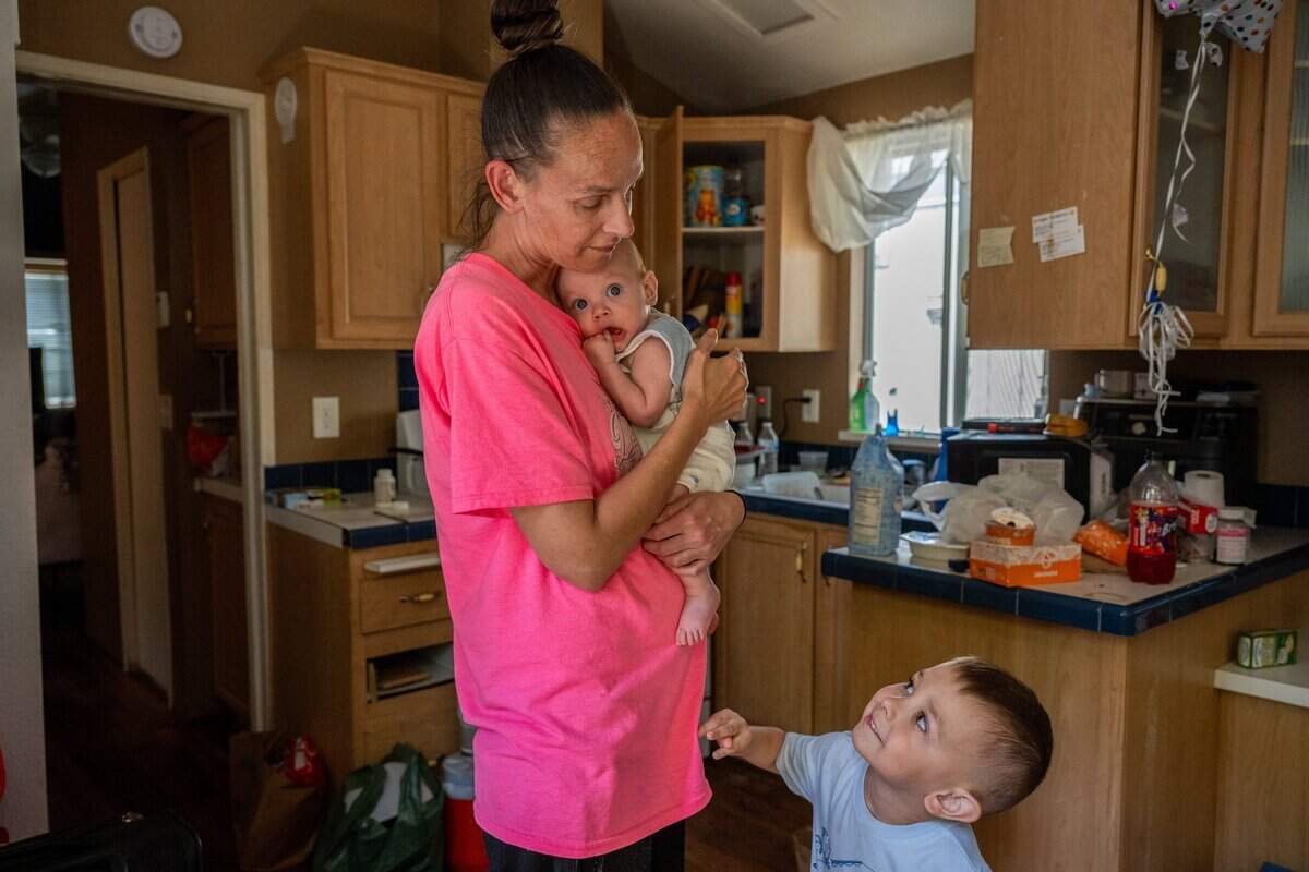 Patricia Miller holds her 4-month-old son, Hayden, as her other son, Hunter, 4, vies for her attention in a city-funded cottage at Arden Acres in Sacramento on Tuesday, June 2, 2026. Miller said she has no place to go after the city changed the program, leaving families without shelter. She does not own a vehicle.