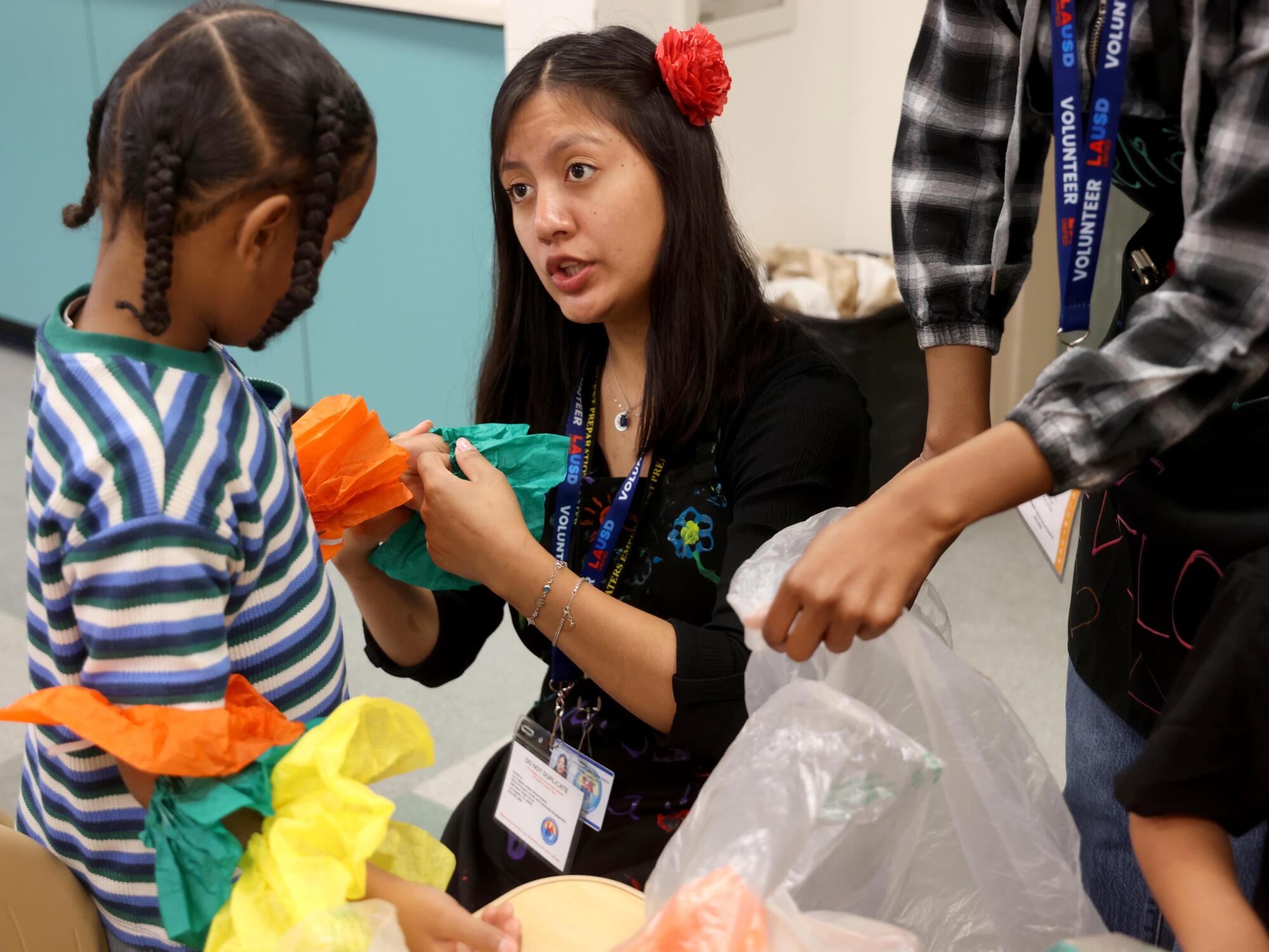 An adult school student talks to a preschooler.