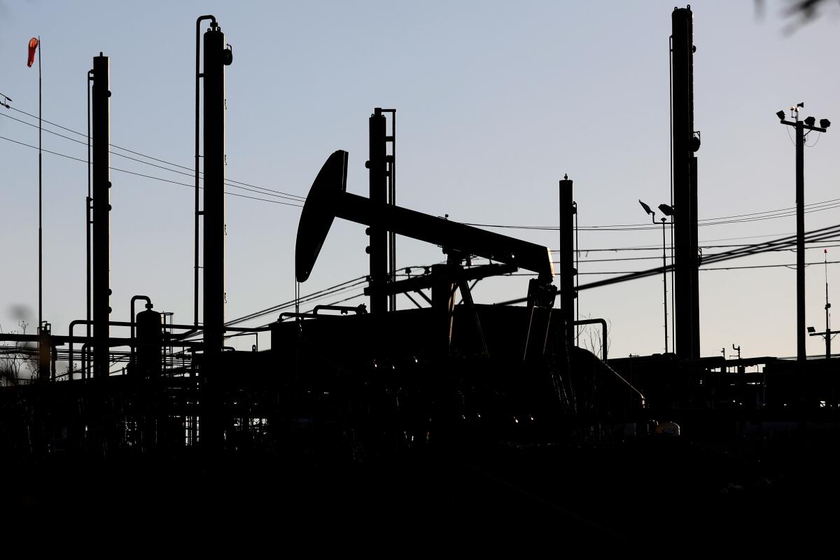 Oil pump jacks are seen in silhouette.