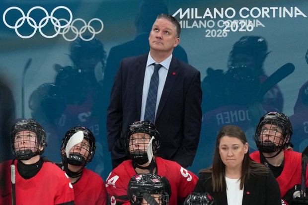 Canada head coach Troy Ryan, top center, watches a replay during the second period of a women's ice hockey semifinal match against Switzerland at the 2026 Winter Olympics, in Milan, Italy, Monday, Feb. 16, 2026. (AP Photo/Carolyn Kaster)