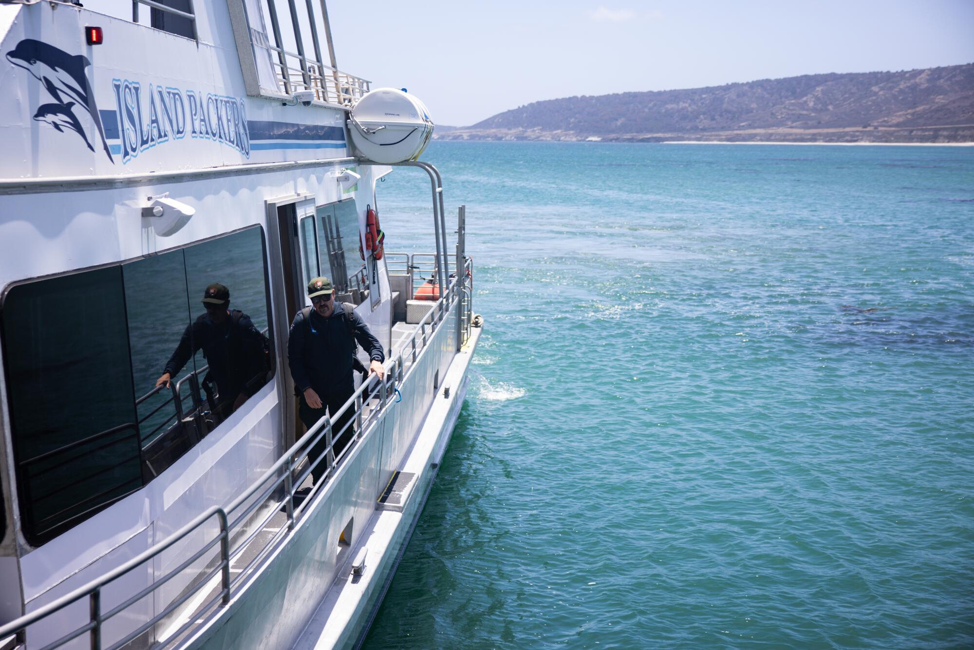 A man walks along a ferry at sea.