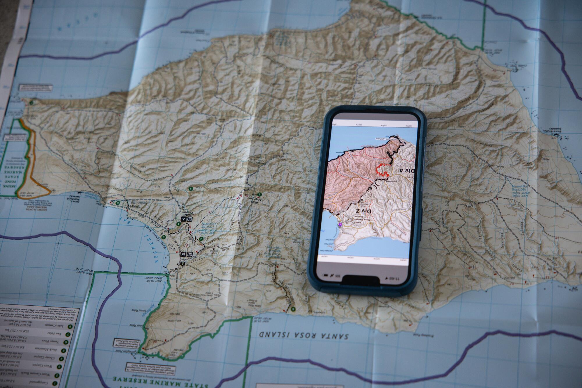 A smartphone rests on a map of an island.