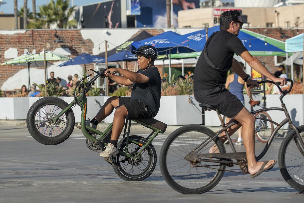 A juvenile riding his e-bike on the Strand in Hermosa Beach.
