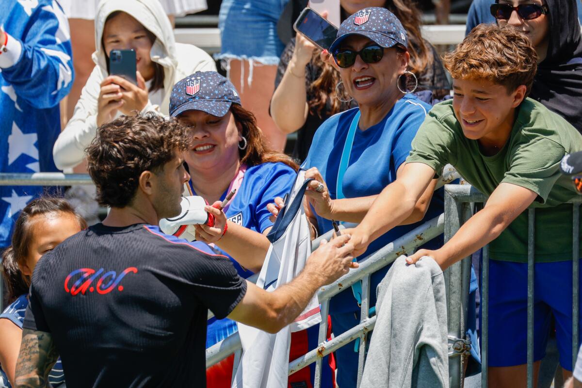 USMNT player Christian Pulisic signs autographs for fans.