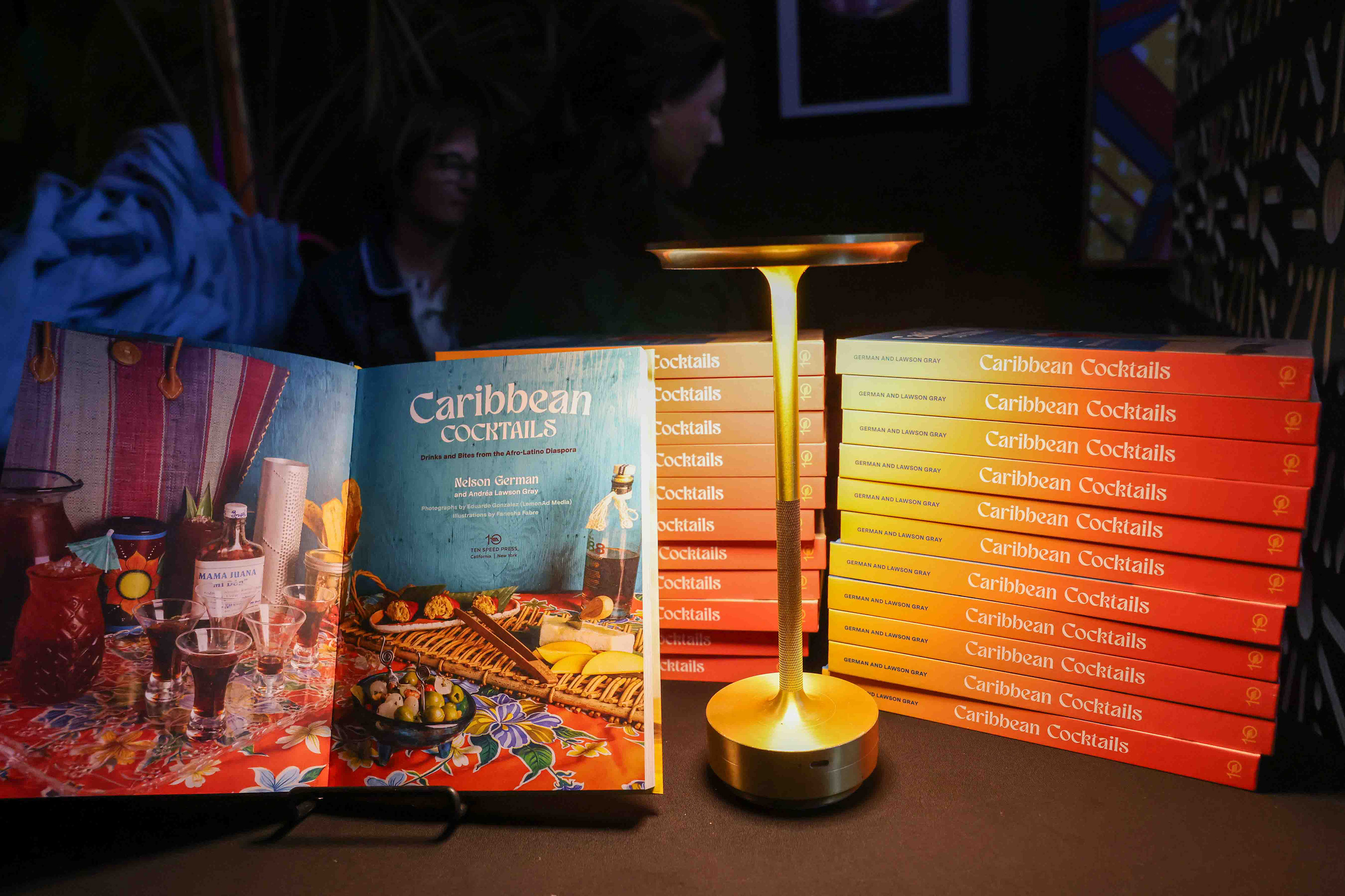 Copies of the book “Caribbean Cocktail” sit on a table...