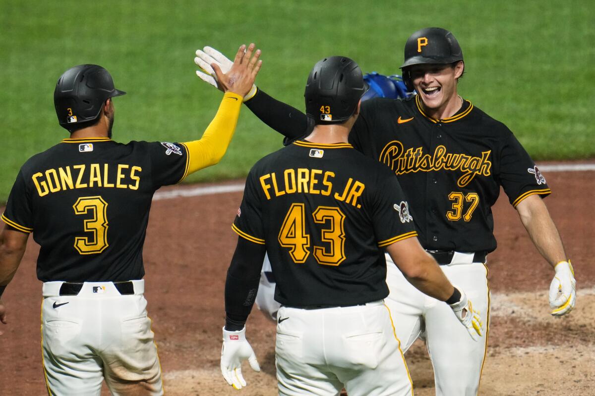 Tyler Callihan is greeted by Pirates teammates after his three-run home in the eighth inning.