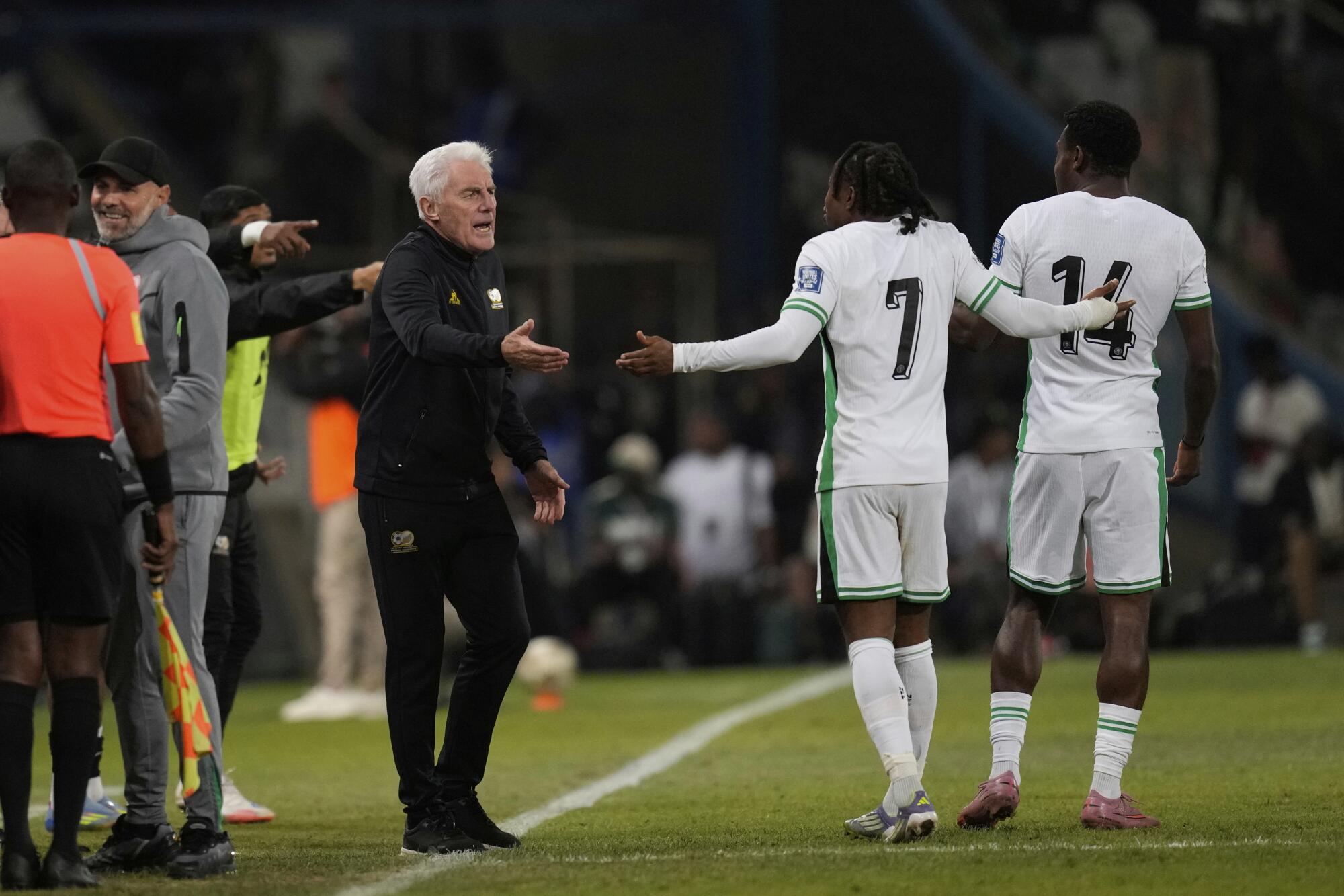 South Africa coach Hugo Broo talks with Nigeria's players during a World Cup qualifying match against Nigeria.